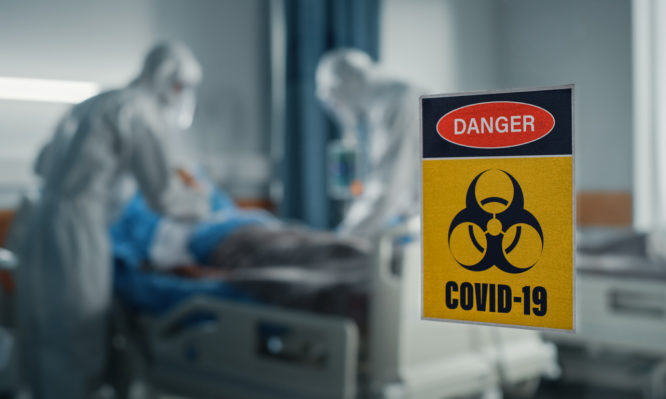 Hospital Coronavirus Emergency Department Ward: Doctors wearing Coveralls, Face Masks Treat, Cure and Save Lives of Patients. Focus on Biohazard Sign on Door, Background Blurred Out of Focus (Hospital Coronavirus Emergency Department Ward: Doctors wea